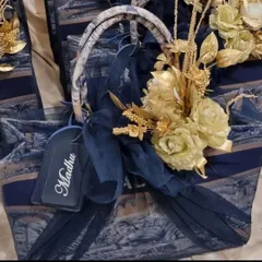 The anniversary gift set, beautifully wrapped with a navy blue tulle and golden flowers, ready to be presented.