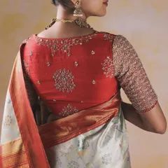 This blouse showcases a unique approach to embroidery placement. Delicate floral and vine motifs are strategically placed on the back and sleeves of this red blouse, creating a design that is both elegant and modern.