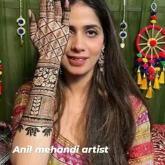 This client is all smiles with her beautiful henna. The design on the back of her hand features a mix of geometric and floral patterns, perfect for her festive attire.