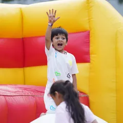 A happy student enjoying a bouncy castle at the CNS Fiesta 2025, a large school event conceptualized by me.