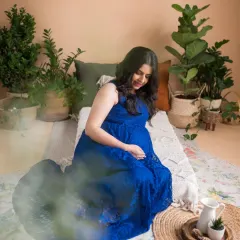 A wider view of our bohemian studio setup, complete with lush greenery and natural textures. This shot captures the peaceful, nesting atmosphere we created for this beautiful maternity session.