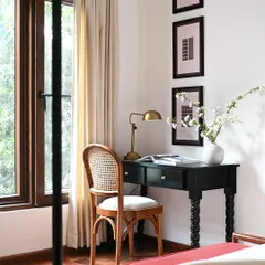 Every bedroom needs a quiet corner. In this master bedroom, I created a small, elegant desk space by the window. The classic writing desk and cane-back chair provide a functional spot for work or reflection without disrupting the room's tranquil atmosphere.