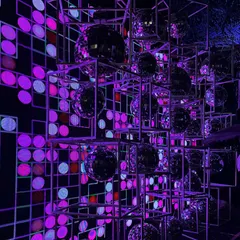 A custom photo booth installation featuring a grid of disco balls against a pixelated light backdrop. This retro yet modern setup was a huge hit and provided the perfect spot for party pictures.