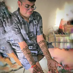A final shot of the groom proudly displaying his full-arm mehndi. The design is a mix of traditional Indian motifs and personalized elements that reflect his style.