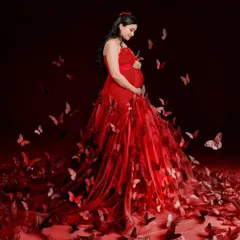 A truly magical shot created with thoughtful editing. The mom-to-be stands in a beautiful red gown as a swirl of red butterflies surrounds her, creating a fairytale moment.