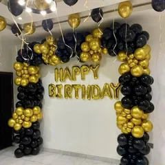 A classic black and gold balloon arch for a stylish birthday celebration. This setup is perfect for creating an elegant photo backdrop in any home.