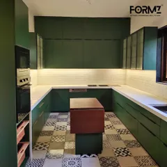 A stunning U-shaped kitchen in a bold matte green finish. This design features a movable central island for flexible prep space, patterned floor tiles, and integrated under-cabinet lighting, creating a perfect balance of modern style and classic charm.