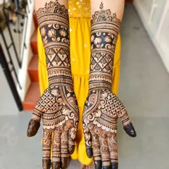 This bridal design features beautiful bands of lotus motifs and criss-cross patterns. The contrast between the filled and empty spaces makes the floral work pop.