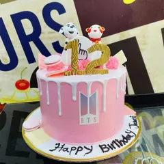 A 2kg pink drip cake for the BTS Army, featuring the band's logo and cute character toppers.