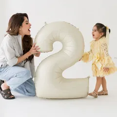 A playful moment between mother and daughter during a second birthday photoshoot. Their interaction is full of life and laughter.
