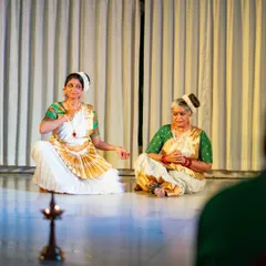 A seated scene from "Uthara," performed in an intimate setting with a traditional lamp, creating a unique atmosphere.