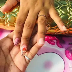 Here I am demonstrating a design for a student. This shows how we work together on techniques like lettering and encapsulation, with a clear nail featuring red heart glitter and the word 'Kiss'.