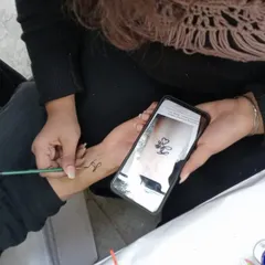 Sometimes clients have a specific design in mind. Here, I'm using a photo on a phone as a reference to create a custom initial tattoo.
