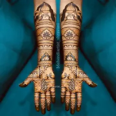 A beautiful example of symmetrical bridal mehendi. The design is balanced with lotus motifs on the forearms and elegant paisley teardrops on the palms.