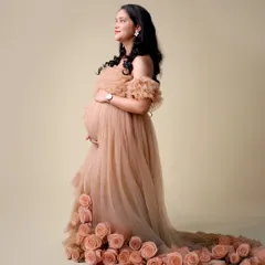 Our rose-train gown is a client favorite. This portrait shows the intricate detail of the floral train on this unique off-the-shoulder tulle dress.