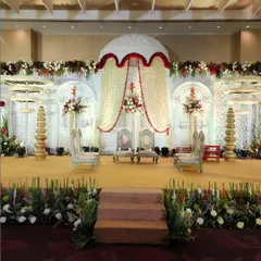 A classic mandap design featuring a dome-shaped floral canopy made of jasmine and rose strings. The white and red color palette offers a timeless and traditional look for the ceremony.