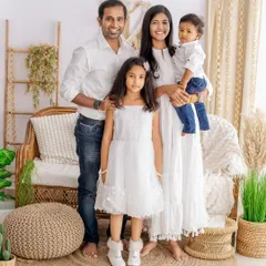 A full-length family portrait that captures everyone's personality. This standing pose in a beautifully styled, rustic setting shows the family's connection and individual style.
