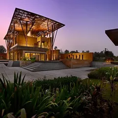The Tree House in Delhi, captured at twilight. Here, architecture becomes a form of nature itself, with a perforated metal canopy that filters light like the leaves of a great tree, creating a sanctuary of dappled light and profound quiet in the heart of the city.