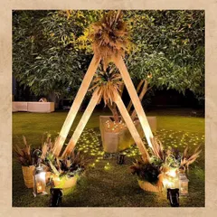 This triangular wooden photobooth is a perfect example of our rustic boho designs. Decorated with pampas grass and surrounded by lanterns and fairy lights, it creates a magical photo spot for an evening outdoor event.