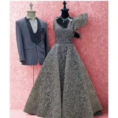 Glamour meets grace. This mannequin pairing shows the same elegant grey gown and tuxedo against a pink backdrop, highlighting its suitability for a romantic event.