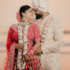 A joyful close up of a couple after their beach wedding ceremony. Their happy smiles and the golden light of the sunset create a perfect memory.