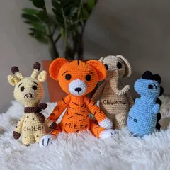 A custom set of amigurumi animals, each with their own name. This group includes Chittu the giraffe, Mittu the tiger, Chunnu the elephant, and Ira the dinosaur.