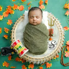Another angle of the little Shiv, with the Damaru drum placed beside him. The green and orange color palette evokes a feeling of nature and divinity.