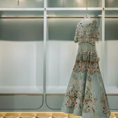 The display systems in the fashion studio are designed to be minimal yet elegant. A single garment is highlighted against a serene, mint-green backdrop with integrated lighting, turning the clothing itself into a work of art.
