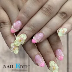 We can create 3D floral designs that seem to bloom right off your nails. This set features translucent yellow sculpted flowers on a French manicure base with bright pink tips, perfect for a vibrant, spring-inspired style.