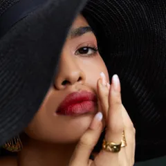 A tight close-up focusing on the model's expression and makeup. In fashion photography, these detail shots are crucial for showcasing beauty and accessory elements.