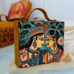 This bag is adorned with a traditional painting of Radha and Krishna, making it a piece of wearable art. The rich colors and intricate details are printed on matte satin, framed by a tan suede body.
