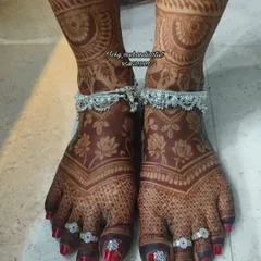 The rich, dark stain on this bride's feet is the result of our natural henna and proper aftercare. The design with lotus flowers and checks is beautifully highlighted.
