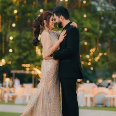 A romantic embrace at an outdoor reception. The beautiful bokeh from the string lights creates a magical atmosphere for this couple's portrait.