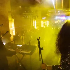 A view from the stage into a sea of yellow light and smoke. This shot captures the epic scale and atmosphere of our live concerts while on tour.