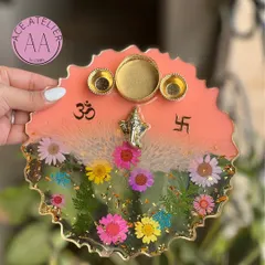 This handmade resin pooja thali, decorated with real preserved flowers and sacred icons, is designed to bring so much beauty to your sacred rituals. This piece features a lovely peach and floral design with a Ganesh idol.