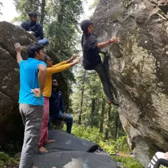 The 'Walk in the Park' boulder problem in Sethan is a classic. Here, you see our climbers working together, spotting and encouraging each other as they figure out the sequence of moves.