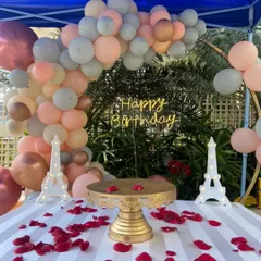 We create intimate and romantic settings for your most personal celebrations. This beautiful outdoor birthday surprise features a custom balloon garland, elegant Eiffel Tower props, and a perfectly set cake table with scattered rose petals.