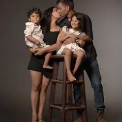 This black and white family portrait has the quality of a classic painting. The dark background makes the family's loving embrace the undeniable heart of the image.