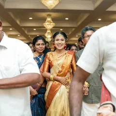 A radiant South Indian bride making her entrance, her smile lighting up the entire hall. We capture the energy of the procession and the anticipation.