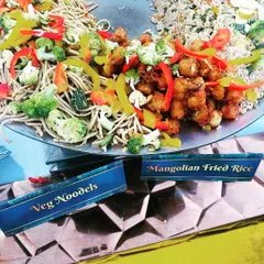A vibrant display of vegetarian noodles and Mongolian fried rice at a live tava station. This showcases the colorful and delicious Chinese cuisine options I provide for corporate events.