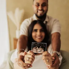 A creative shot focusing on the sonogram, with the happy parents-to-be blurred lovingly in the background.