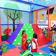 Our play area is a place for fun and friendship. Here, two girls in beautiful traditional attire enjoy the climbing structure, showing how we blend everyday play with festive celebrations.