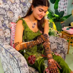 A candid shot of a bride admiring her beautiful, detailed henna design.