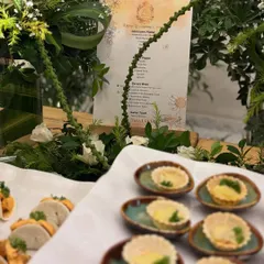 A platter of delicate mini quiches and veg tacos, part of the spread for The Thalasso Luxe launch. In the background, you can see the custom-printed menu I designed for the event.