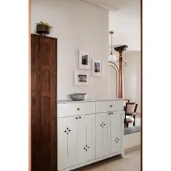 The foyer of the 'Kanasu' home sets a nostalgic tone with frames showing life in Mangalore. A vintage-style cabinet with antique handles embodies the harmony of old-world charm and contemporary functionality.