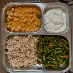 A simple, repeated meal of brown rice, fresh rajma curry, sautéed beans, and Greek yogurt. Repetition is normal in a busy week, and it's better to eat a healthy meal you enjoy than to struggle for constant variety.