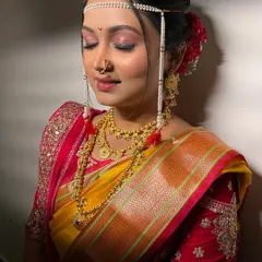 A detailed shot of the bridal makeup, focusing on the flawless base and soft eyeshadow. The traditional bindi and nath complete this classic Maharashtrian look.