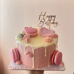 Another view of the pink chocolate drip cake, showing the "Happy Birthday" topper and delicate decorations.