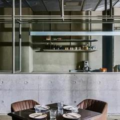 At the Evoo restaurant in Gurugram, the open kitchen is framed as a stage for culinary performance. The structure of exposed concrete and steel defines the space, creating an industrial aesthetic that complements the modern Italian dining experience.