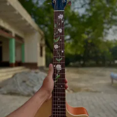 Here is the guitar I recently painted. I added a delicate floral vine design to the fretboard, making the instrument completely unique.
